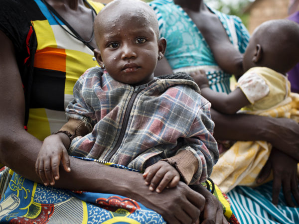 A mother holds her baby at an Early Childhood Development session that is being run by a Community Health Officer who has undergone training by Jhpiego, in Sijri Veng Veng village, Ghana, on Thursday, June 6 2018. This is one of the poorest regions in Ghana and parents struggle to grow enough food for their children to eat; and have no money to buy toys. Health workers trained by MCSP teach mothers how to make toys from items they can find in their homes and how to play with their children. The project has been running for six months in the community and parents have seen a big change in how their babies are developing. Jhpiego has been working throughout Ghana to improve the lives of newborn babies and their mothers.