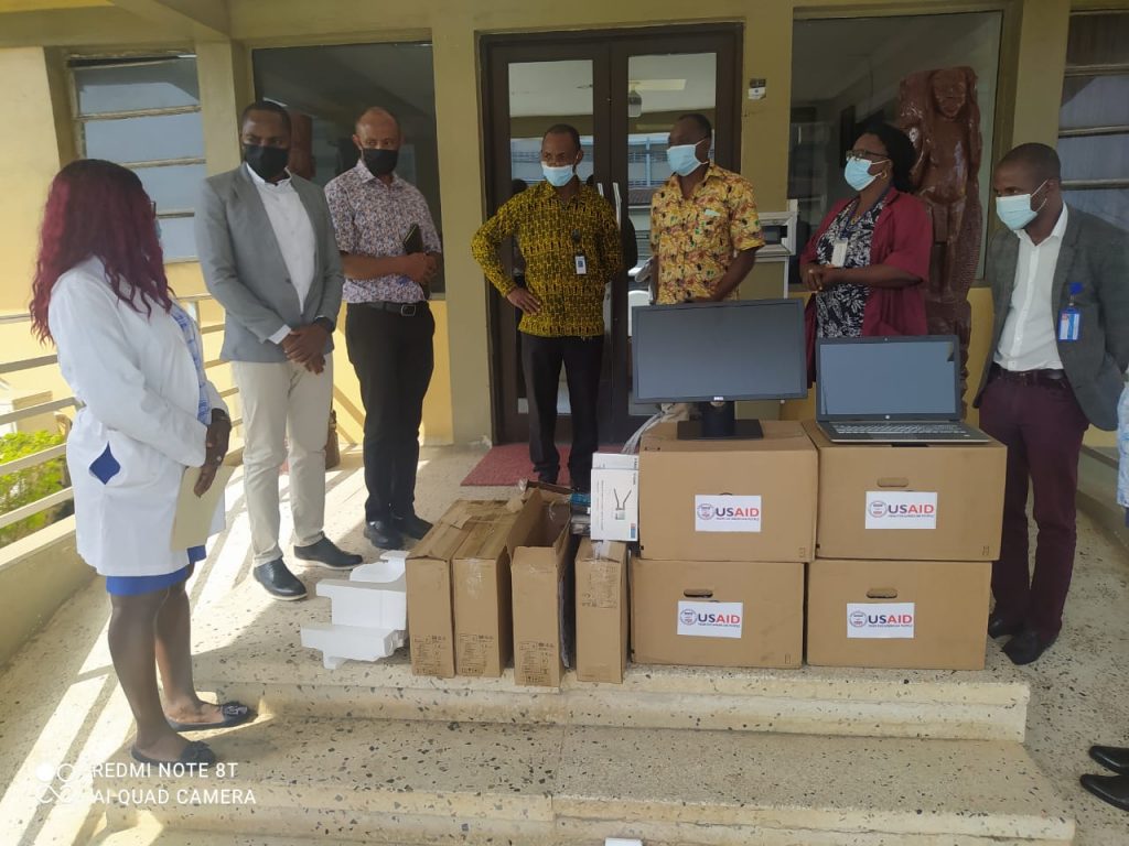 Cross section of the Jhpiego and JFKMC teams during the delivery of four desktop and one laptop computers to the facility for data systems improvement. Photo credit: JFKMC