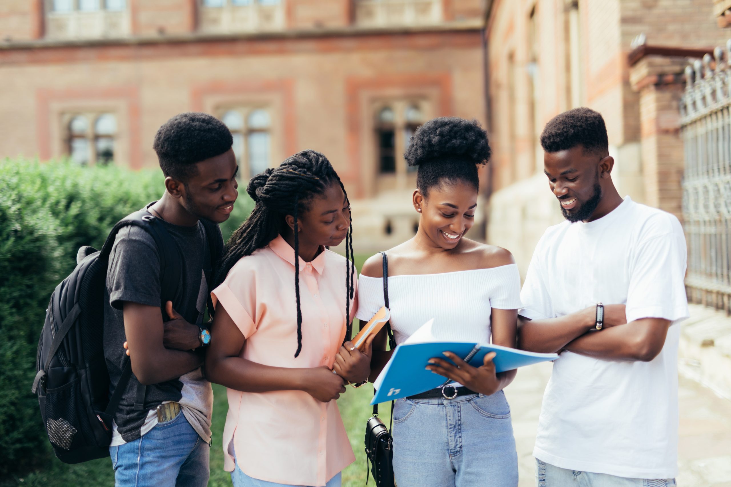 Group of young african people are studying together in university. Students outdoors.